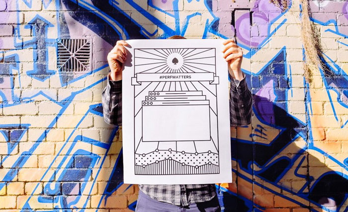 A photo of a man holding a poster with the hashtag perfmatters printed on it